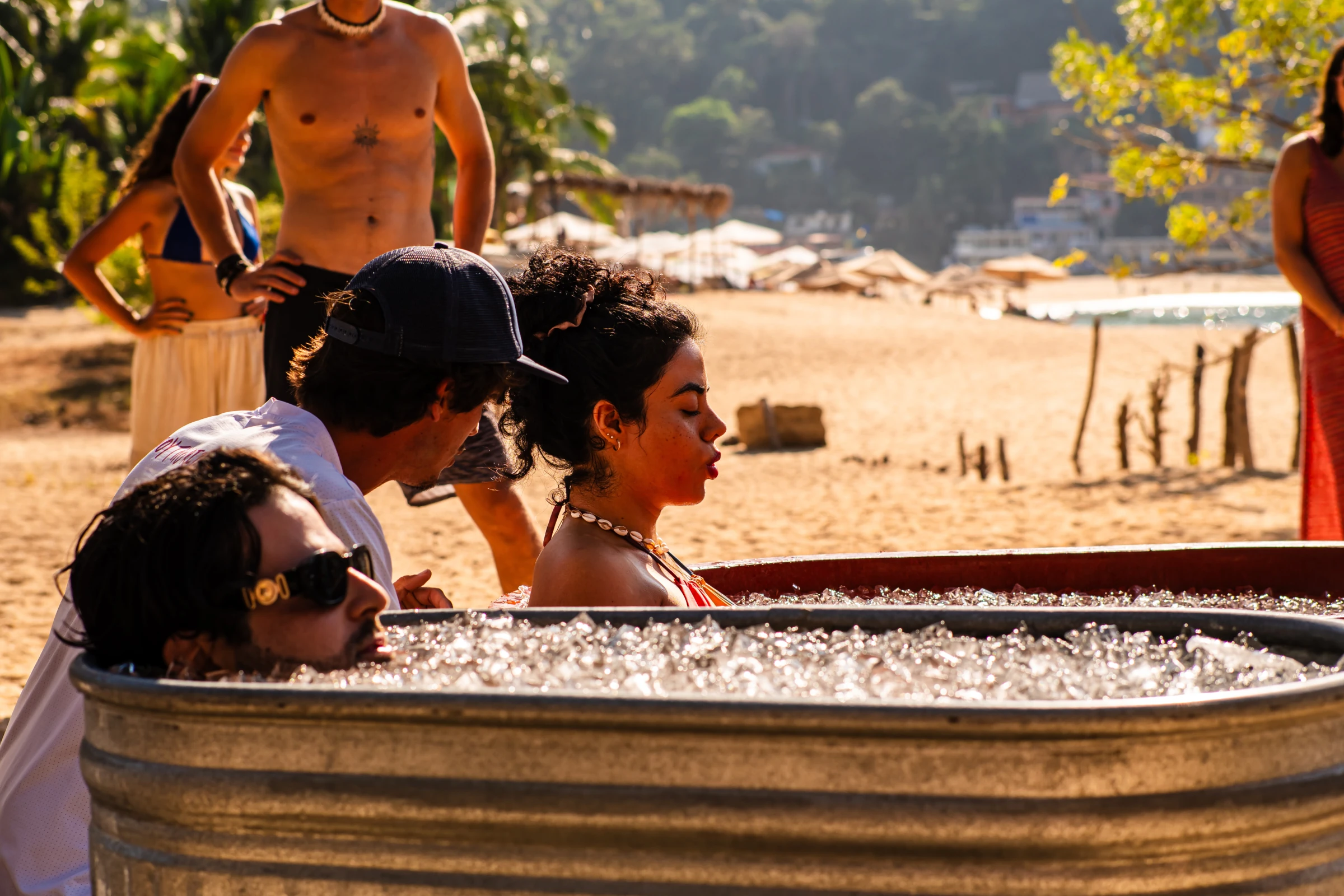 Personas reunidas junto a una cabina de DJ en la playa