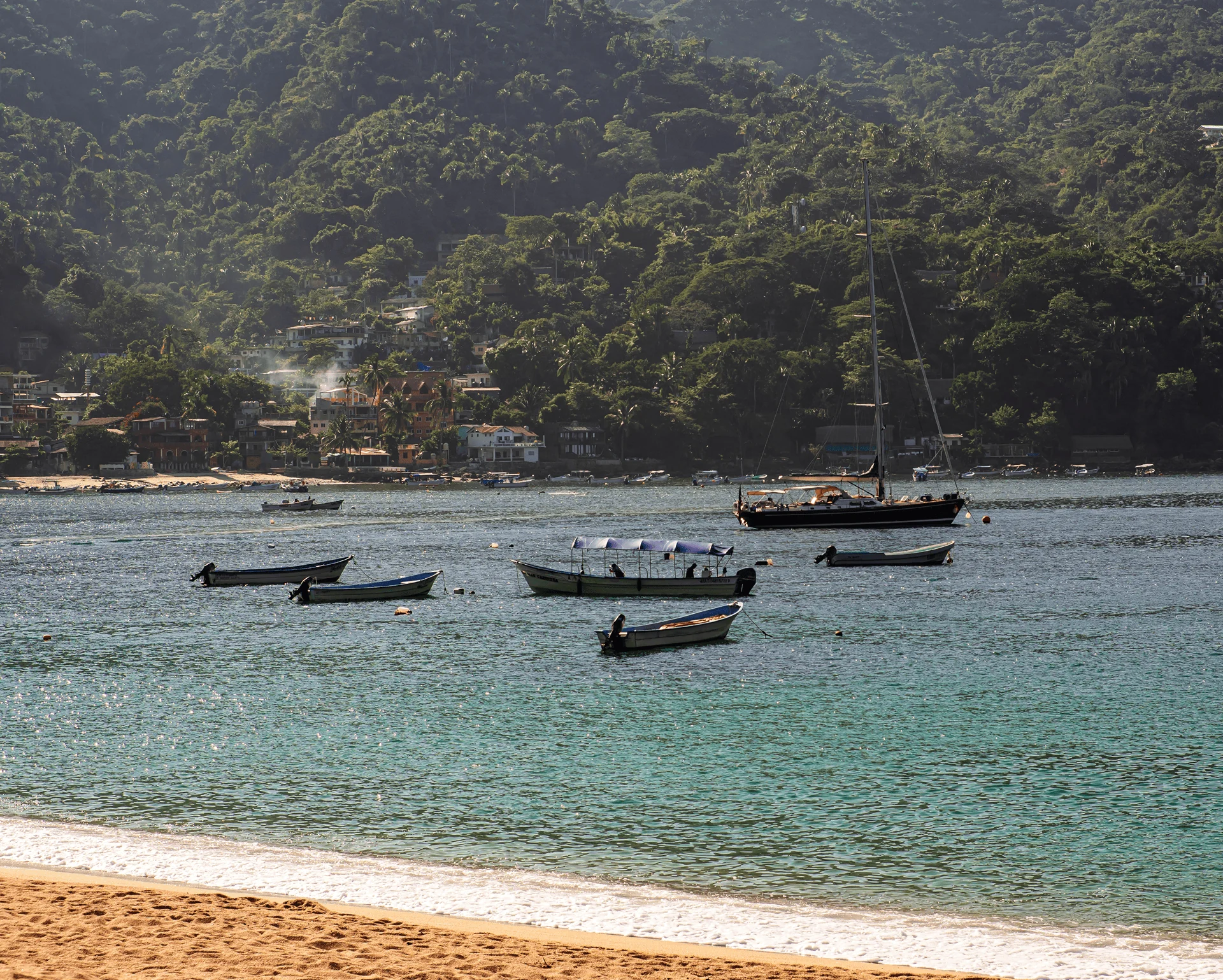 Vista de Yelapa desde el agua, con la selva y el pueblo al fondo